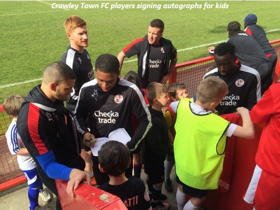 Crawley Town FC players signing autographs for kids